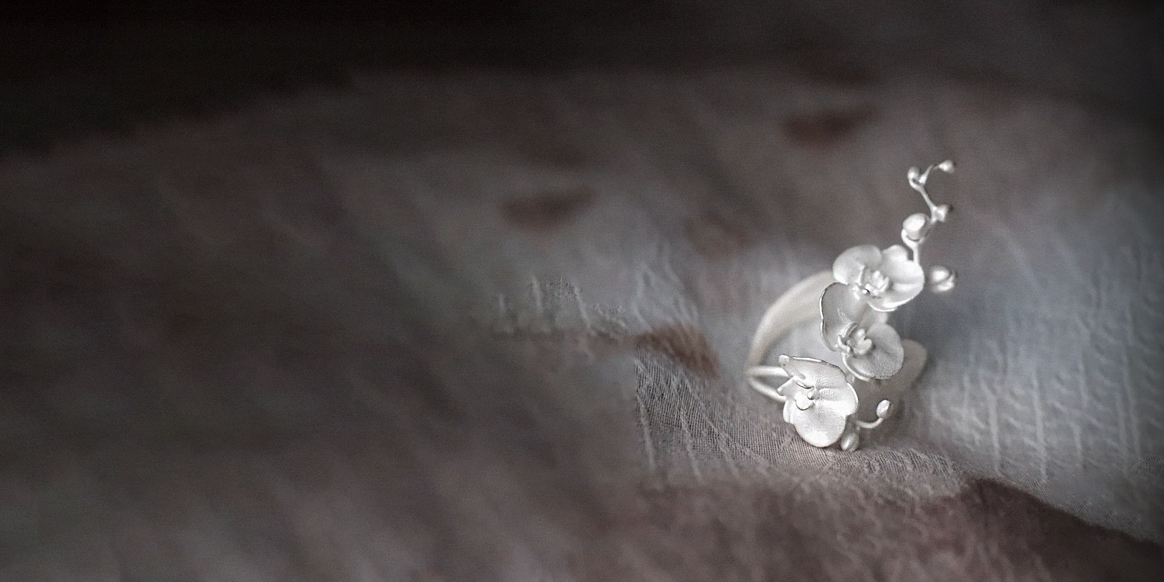 A close-up of the Reblooming Orchid Ring in polished 925 sterling silver, showcasing its fluid, organic lines.